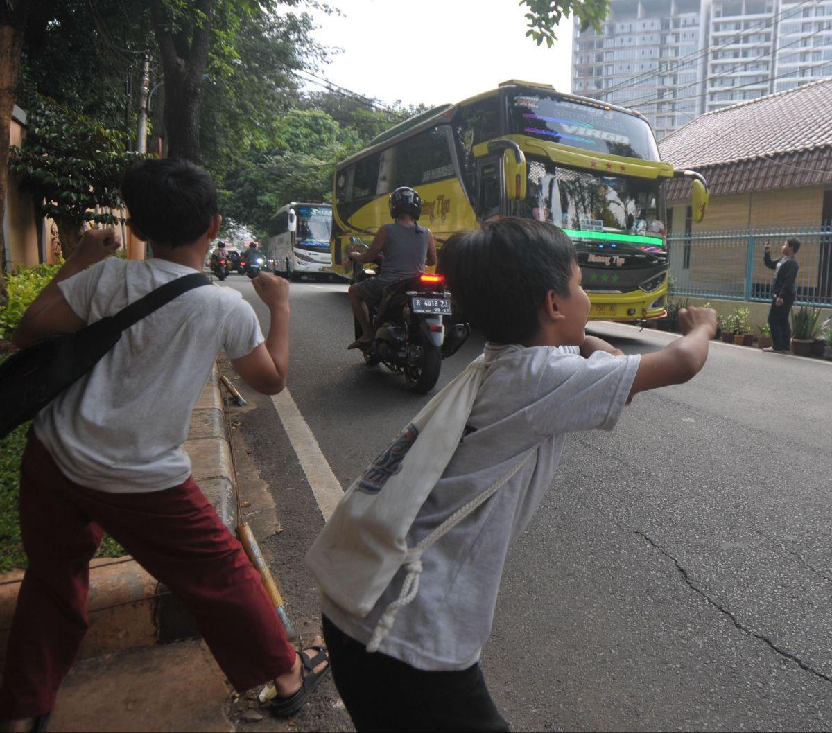 Sejumlah anak berjoget ketika mendengarkan klakson telolet atau klakson tidak standar, yang biasanya mengeluarkan nada-nada tak biasa, dari sebuah bus yang meninggalkan kawasan Taman Margasatwa Ragunan, Jakarta, Kamis (13/6/2024). Meski mengancam nyawa, n