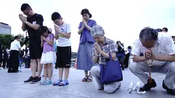 Warga Jepang berdoa untuk para korban bom atom menjelang peringatan di Hiroshima Peace Memorial Park, pusat kota Hiroshima, Selasa (5/8/2019). Pemerintah Jepang menggelar peringatan jatuhnya bom atom di Kota Hiroshoma 74 tahun lalu yang menandai berakhirnya Perang Dunia (PD) II. (JIJI PRESS / AFP)