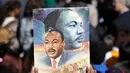 Seorang pria memegang poster Martin Luther King Jr saat menghadiri peringantan 50 tahun pembunuhan Martin Luther King Jr di Memphis, Tennessee (4/4). (AP/Mark Humprey)