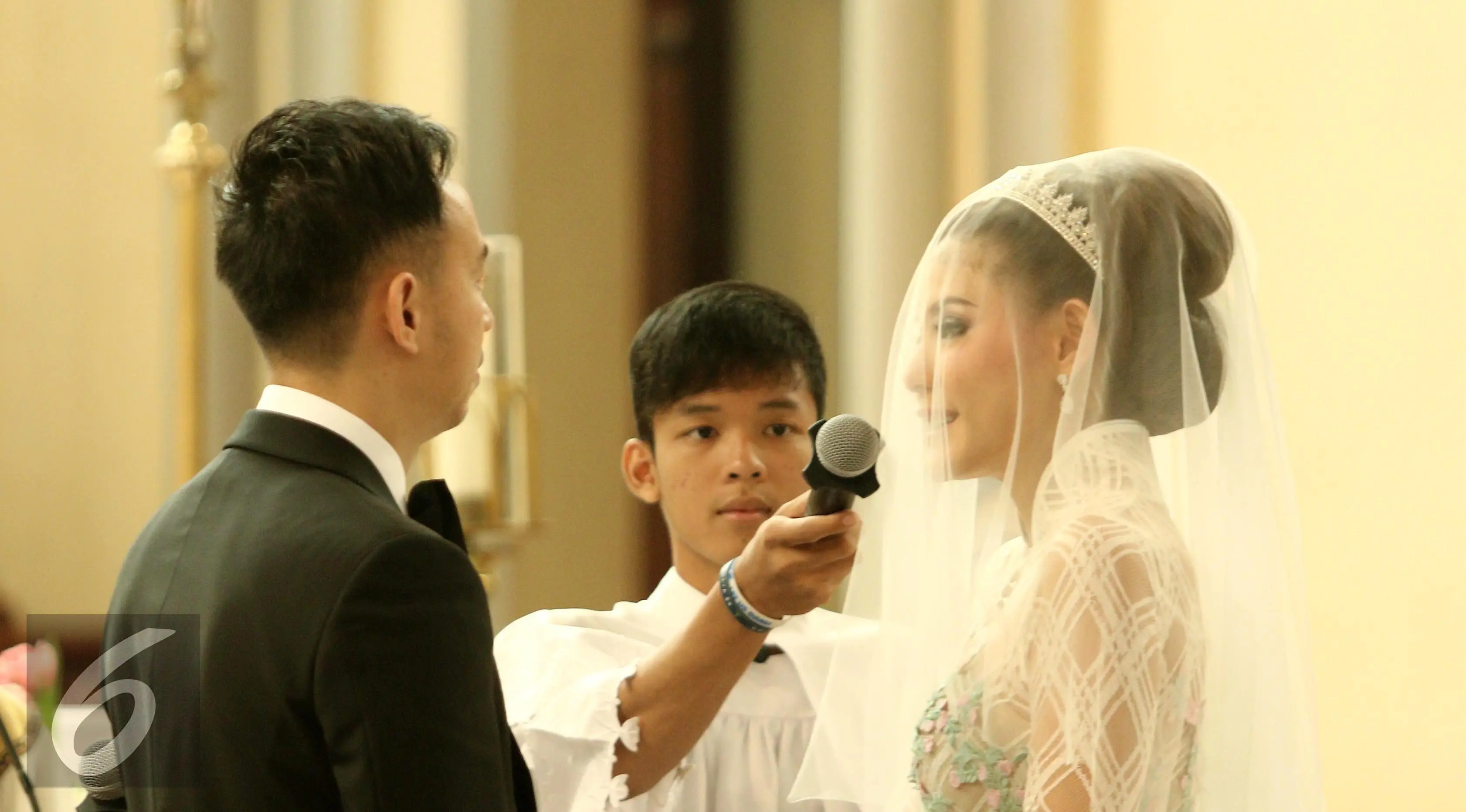 Olga Lydia dan Aris Utama saat melakukan proses pernikahan di Gereja Katedral, Jakarta, Jumat (21/4/2017). (Herman Zakharia/Liputan6.com)
