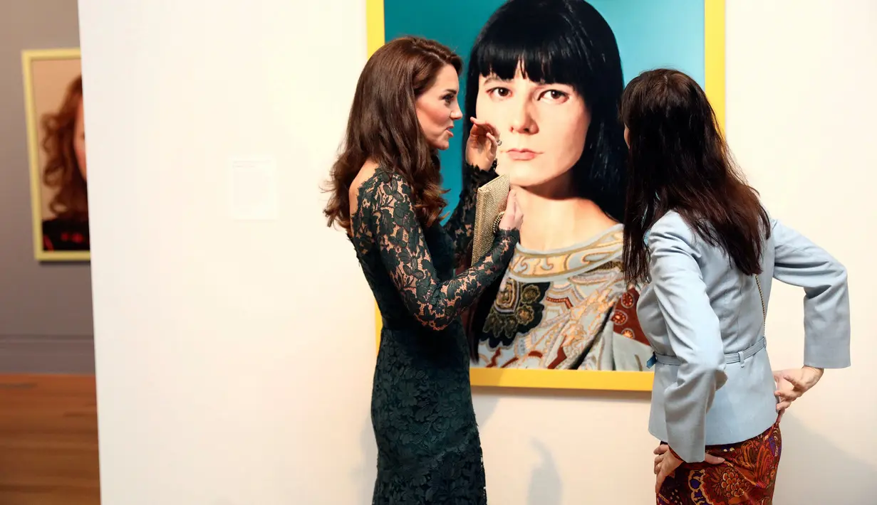 Kate Middleton berbincang dengan seniman Gillian Wearing saat pameran Portrait Gala 2017 di National Portrait Gallery, London (28/3). Kate tampil anggun mengenakan gaun berwarna hijau.  (Neil Hall/Pool photo via AP)