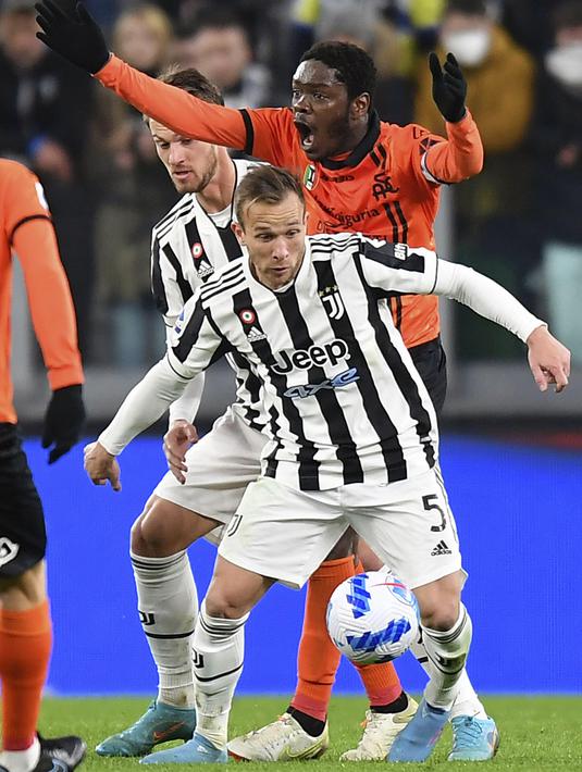 Penyerang Spezia Emmanuel Gyasi berebut bola dengan gelandang Juventus Arthur pada pertandingan Liga Italia pekan ke-28 di Allianz Stadium, Senin (7/3/2022) dini hari WIB. Juventus menang 1-0 atas Spezia lewat gol Alvaro Morata. (Tano Pecoraro/LaPresse via AP)