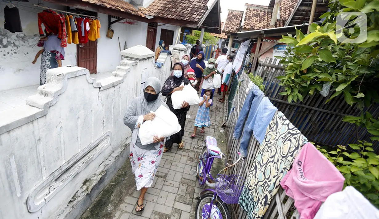 Warga menerima bantuan sembako dari Jurnalis Peduli di Pulau Panjang, Serang, Banten, Sabtu (30/1/2021). Kegiatan Jurnalis Peduli yang bekerjasama dengan BNI dan Jamkrindo bertujuan meringankan beban warga terdampak Covid-19 yang memiliki mata pencarian sebagai nelayan. (Liputan6.com/Pool/JP)