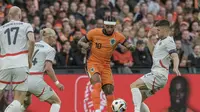 Striker Belanda, Memphis Depay diadang beberapa pemain Islandia dalam uji coba di Stadion Feyenoord, Rotterdam, Selasa (11/6/2024). (AP Photo/Patrick Post)
