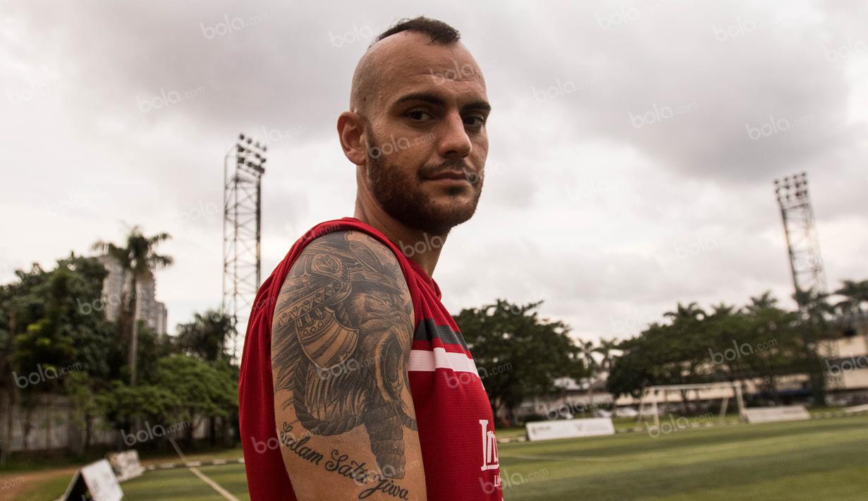 Bek Bali United, Kiko Insa, menunjukan tato bergambar singa dengan tulisan salam satu jiwa yang merupakan identitas Arema, usai latihan di Lapangan Pertamina, Simprug, Jakarta, Rabu (6/4/2016). (Bola.com/Vitalis Yogi Trisna)