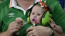 Suporter cilik Republik Irlandia ini tengah menyaksikan laga timnya dengan menggunakan peredang suara pada telinga saat timnya melawan Italia di Stadion Pierre-Mauroy, Villeneuve-d'Ascq,  (22/6/2016). (AFP/Philippe Lopez)