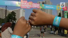 Pengunjung memperlihatkan gelang tangan KapanLagi Buka Bareng BRI Festival 2024 di Plaza Timur Senayan, Jakarta, Sabtu (23/3/2024). (Liputan6.com/Herman Zakharia)