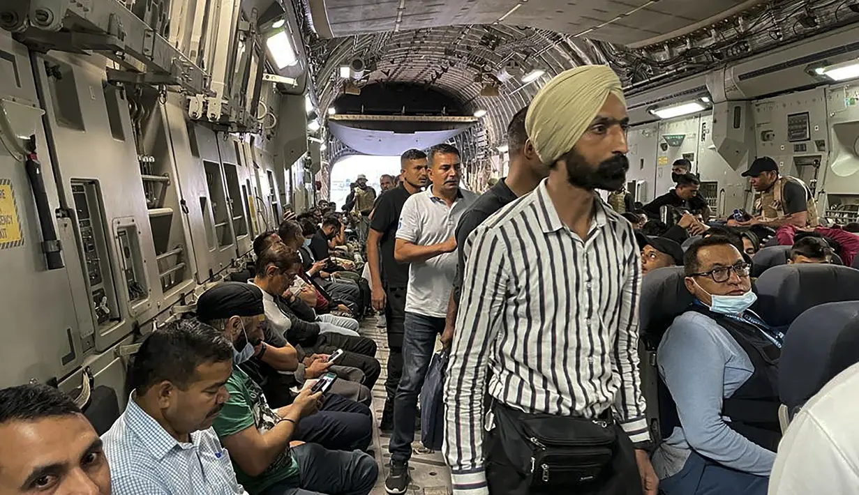 Warga negara India duduk di atas pesawat militer India untuk dievakuasi setelah pengambilalihan Afghanistan oleh pejuang Taliban di bandara di Kabul (17/8/2021). India mengevakuasi lebih dari 170 warganya dari Kabul pada Selasa, termasuk Duta Besar India untuk Afghanistan. (AFP Photo)