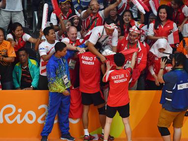 Tontowi Ahmad dan Liliyana Natsir merayakan kemenangan bersama suporter Indonesia usai meraih medali Emas Olimpiade Rio 2016 dari Cabang ganda Campuran Bulutangkis di Stadion Riocentro, Rio de Janeiro, (17/8/2016). (AFP/Ben Stansall)