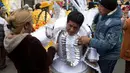 Seorang peserta bersiap mengenakan kostum untuk mengikuti parade tahunan ""El Senor del Gran Poder" di La Paz, Bolivia (10/6). Parade ini merupakan bentuk penghormatan mereka kepada sang dewa. (AP Photo / Juan Karita)