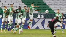 Bek Real Madrid, Sergio Ramos, melepaskan tendangan bebas ke gawang Real Betis pada laga La Liga di Stadion Benito Villamarin, Minggu (27/9/2020). Real Madrid menang dengan skor 3-2. (AP Photo/Angel Fernandez)
