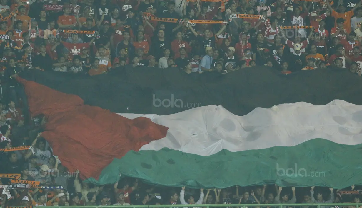 Suporter Persija, The Jakmania, mengibarkan bendera Palestina saat melawan Bhayangkara FC pada laga Liga 1 di Stadion Patriot Bekasi, Jawa Barat, Sabtu (29/7/2017). Persija menang 1-0 atas Bhayangkara FC. (Bola.com/M Iqbal Ichsan)