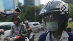 Polantas membuat surat tilang untuk pengendara motor ketika berlangsungnya Operasi Patuh Jaya 2018 di ruas Jalan DI Panjaitan, Jakarta Timur, Jumat (27/4). Razia ini berlangsung selama 14 hari, dari 26 April sampai 5 Mei 2018. (Merdeka.com/Imam Buhori)