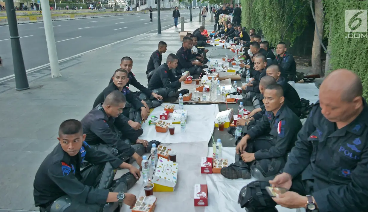 Sejumlah Korps Brimob menikmati menu buka puasa disela penjagaan mereka di kawasan MH Thamrin, Jakarta, Jumat (24/5/2019). Usai kerusuhan 22 Mei 2019, penjagaan di kawasan jalan MH Thamrin sampai Jumat, 24 Mei 2019 masih terus dilakukan oleh aparat kepolisian. (Liputan6.com/Herman Zakharia)