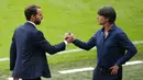 Manajer Inggris Gareth Southgate (kiri) berjabat tangan dengan manajer Jerman Joachim Loew pada akhir pertandingan babak 16 besar Euro 2020 antara Inggris dan Jerman di Stadion Wembley, London, Inggris, Selasa (29/6/2021). Inggris menang 2-0. (John Sibley/Pool via AP)
