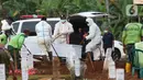 Petugas melakukan pemakaman jenazah dengan protokol COVID-19 di TPU Pondok Ranggon, Jakarta, Kamis (12/10/2020). Gubernur DKI Jakarta Anies Baswedan menganggarkan Rp254 miliar guna menambah lahan pemakaman jenazah dengan protokol Covid-19. (Liputan6.com/Helmi Fithriansyah)