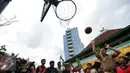 Gubernur DKI Jakarta Basuki T Purnama saat menjajal memasukkan bola ke dalam ring basket seusai meresmikan Ruang Publik Terpadu Ramah Anak (RPTRA) Intiland Teduh, Karet Tengsin, Jakarta, Rabu (30/12). (Liputan6.com/Yoppy Renato)