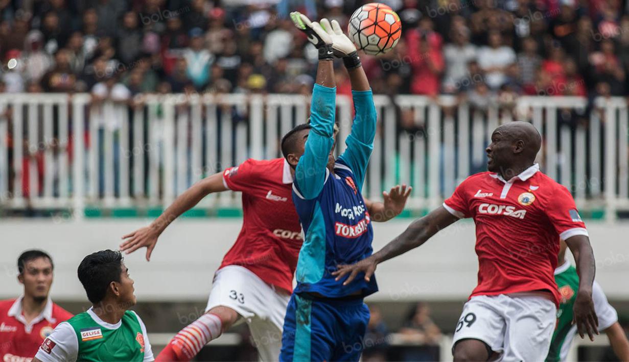 Kiper PS TNI, Teguh Amiruddin, duel udara dengan striker Persija Jakarta, Emmanuel Kenmogne, pada laga Torabika Soccer Championship 2016 di Stadion Pakansari, Bogor, Jumat (15/10/2016). Persija menang 2-1 atas PS TNI. (Bola.com/Vitalis Yogi Trisna)