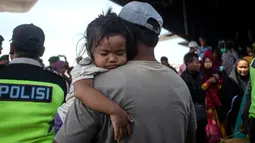 Sejumlah warga korban gempa dan tsunami Palu-Donggala turun dari pesawat saat tiba di Surabaya (4/10). Banyak anak-anak yang terpisah dari keluarganya setelah bencana gempa-tsunami melanda Palu dan Donggala pada 28 September. (AFP Photo/Juni Kriswanto)