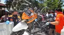 Polisi memindahkan sepeda motor yang digunakan dalam aksi bom bunuh diri saat rekonstruksi di Gereja Katedral Makassar, Sulawesi Selatan, Senin (29/3/2021). Teror bom yang terjadi pada Minggu (28/3) di pintu masuk halaman gereja tersebut melukai sejumlah orang. (INDRA ABRIYANTO/AFP)