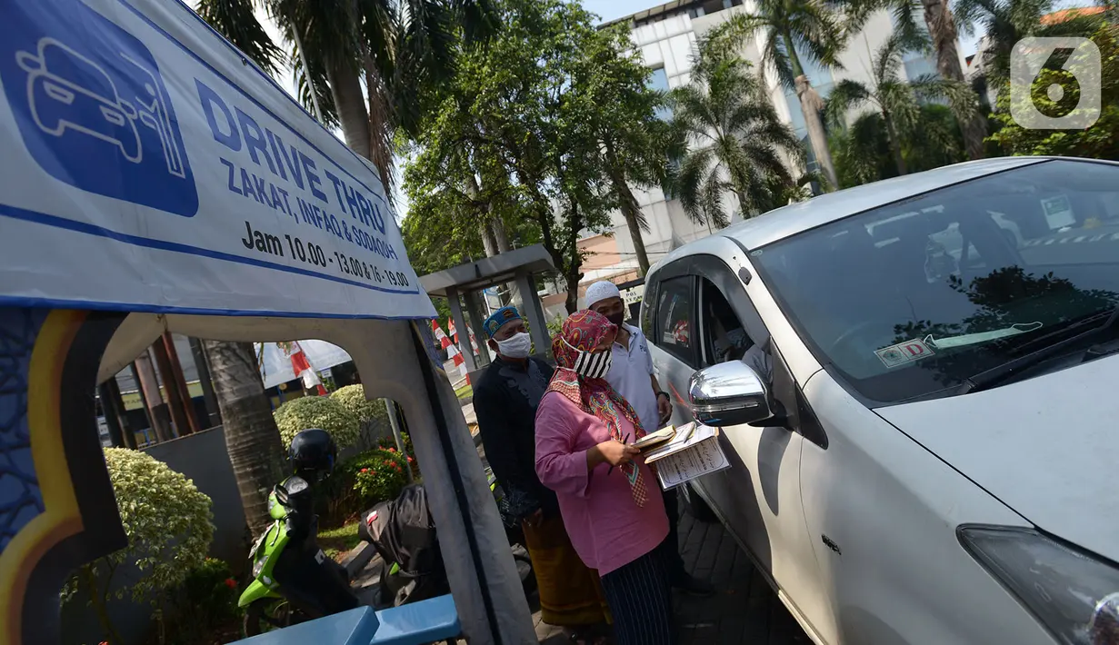 Panitia zakat fitra melakukan pengisian data di Masjid Nurul Hidaya, Jakarta, Sabtu (16/5/2020). Di tengah pandemi Covid-19 panitia masjid membuat lokasi penerima zakat dengan drive thru. (merdeka.com/Imam Buhori)