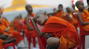 Seorang Biksu Buddha tertidur di kursi saat menunggu acara penerimaan sedekah di kuil Wat Phra Dhammakaya, Bangkok, Thailand, (22/4). Acara ini dihadiri lebih dari 100.000 biksu di Pathum Thani. (REUTERS / Jorge Silva)