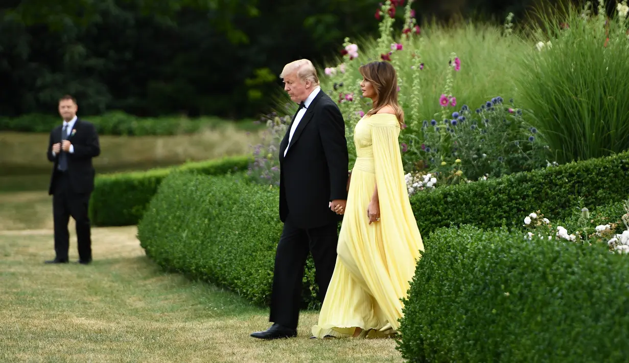 Presiden AS Donald Trump dan Melania Trump meninggalkan Winfield House di London, Kamis (12/7). Mengawali kunjungannya pasangan Trump ini menghadiri gala dinner bersama dengan PM Theresa May di Bleinheim Palace, Inggris. (Brendan Smialowski/AFP)