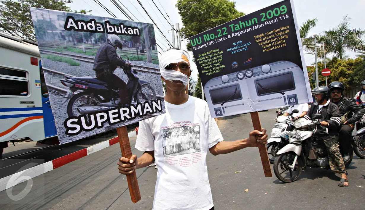 Komunitas Indonesian Railway Preservation Society melakukan aksi Kampanye Keamanan Perlintasan Sebidang Kereta Api di Menteng, Jakarta, Kamis (15/10). Kampanye itu guna menyadarkan bahaya menerobos perlintasan kereta api. (Liputan6.com/Immanuel Antonius)
