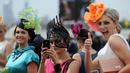 Sekumpulan wanita berfoto bersama saat menghadiri balap kuda Melbourne di arena pacuan kuda Flemington Racecourse di Melbourne, Australia (1/11). Acara ini berlangsung dari September hingga pertengahan November. (AFP/Paul Crock)