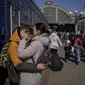 Seorang ibu memeluk putranya yang melarikan diri dari kota Mariupol yang terkepung dan tiba di stasiun kereta api di Lviv, pada 20 Maret 2022. Pada Hari 25 perang Rusia di Ukraina, kehidupan yang kacau, perpisahan yang pahit tertangkap dalam foto-foto Associated Press. (AP Photo/Bernat Armangue)
