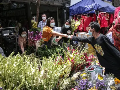 Penjual melayani pembeli bunga hias di Pasar Petak Sembilan, Glodok, Jakarta, Senin (31/1/2022). Jelang tahun baru Imlek 2573 sejumlah bunga seperti sedap malam, aster, mawar dan lainnya mulai banyak dicari warga Tionghoa untuk sembahyang. (Liputan6.com/Faizal Fanani)