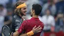 Petenis Yunani, Stefanos Tsitsipas memeluk Novak Djokovic dari Serbia setelah pertandingan perempat final tunggal putra tenis Shanghai Masters di Qizhong Forest Sports City Tennis Center di Shanghai, China (11/10/2019). Tsitsipas menang 3-6, 7-5, 6-3 atas Djokovic. (AP Photo/Andy Wong)