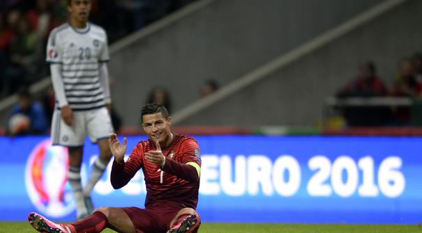 Bintang Portugal Cristiano Ronaldo bertpuk tangan saat terjatuh pada laga Kualifikasi Piala Eropa 2016 Grup I di Municipal stadium, Braga, Kamis (8/10/2015). Portugal menang atas Denmark1-0. (AFP Photo/ Miguel Riopa)