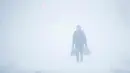 Seorang pria melewati badai salju di Atlantic City, NJ (4/1). Badai salju yang melanda sebagian Amerika Serikat telah membawa salju dan angin kencang. (AP Photo / Matt Rourke)