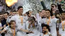 Pemain Real Madrid Sergio Ramos (tengah) mencium trofi juara Piala Super Spanyol bersama rekan-reakannya usai mengalahkan Atletico Madrid pada pertandingan final di King Abdullah Stadium, Jeddah, Arab Saudi, Senin (13/1/2020). Real Madrid menang adu penalti 4-1. (AP Photo/Hassan Ammar)