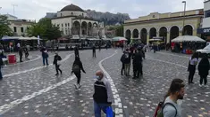 Pejalan kaki, beberapa mengenakan masker, berjalan di Monastiraki square, Athena, Selasa (9/11/2021). Yunani melaporkan rekor tertinggi baru kasus COVID-19 harian pada Senin ketika janji vaksinasi melonjak setelah pembatasan baru untuk warga yang tidak divaksinasi dimulai (AP Photo/Michael Varaklas)