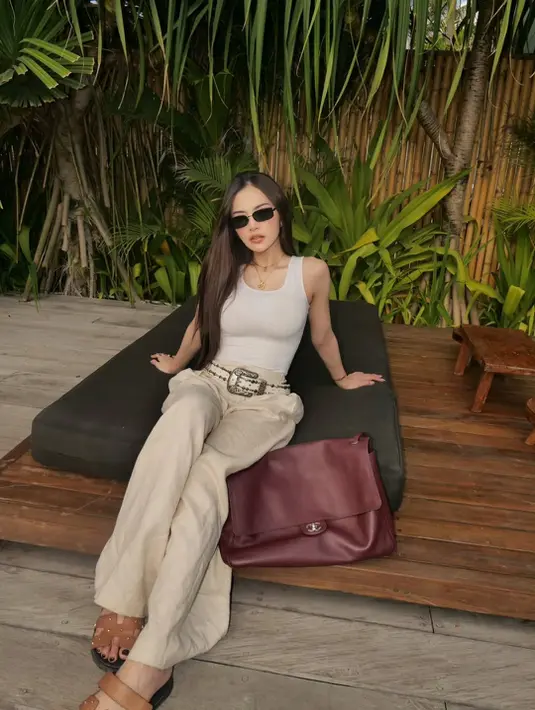 Ibu satu anak ini padukan outfitnya dengan celana linen dan sandal Hermes berwarna cokelat [@mahaliniraharja]