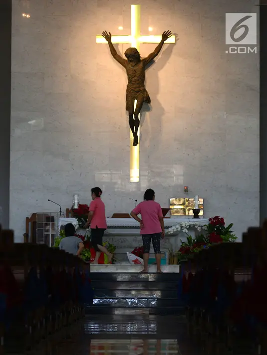 Panitia Gereja Santa Anna merapikan altar dan mempersiapkan tempat peribadatan malam Misa Natal di Duren Sawit, Jakarta, Senin (24/12). Persiapan tersebut untuk menyambut umat Kristiani yang akan beribadah pada malam Misa Natal. (Merdeka.com/Imam Buhori)