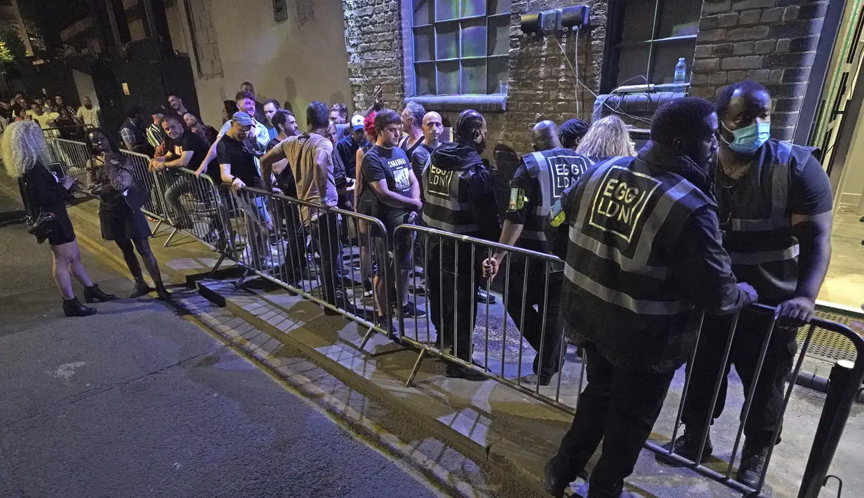 Orang-orang mengantre untuk masuk ke kelab malam Egg di London setelah pembatasan legal virus corona dicabut di Inggris pada tengah malam, Senin (19/7/2021). Ribuan anak muda berdansa semalaman di pesta 'Hari Kebebasan'. (Jonathan Brady/PA via AP)