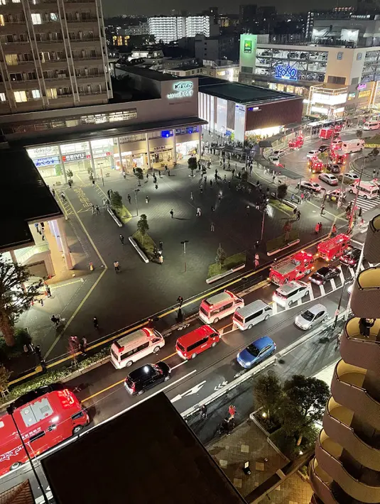 Petugas pemadam kebakaran dan petugas penyelamat berkumpul di luar Stasiun Kokuryo di Jalur Keio di kota Chofu di Tokyo (31/10/2021).  sejumlah saksi mata melihat pria berusia 24 tahun itu menyiram sejumlah sudut kereta dan menyalakan api. (AFP/Jiji Press/STR)