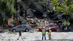 Pemadam kebakaran mengamati puing bangunan apartemen di Sivler Spring, Maryland, Washington DC, Kamis (11/8). Sedikitnya 2 orang tewas dan tujuh lainnya hilang setelah ledakan gas alam yang menyebabkan kebakaran di apartemen itu. (REUTERS/Joshua Roberts)