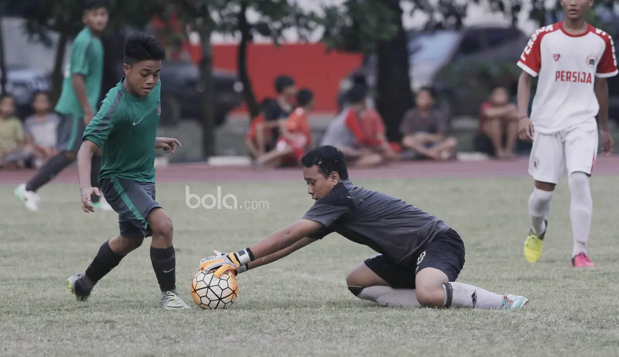 Pemain Timnas Indonesia U-16, Andre Oktavian, berebut bola dengan kiper Persija Jakarta U-16, Muhammad Adam pada laga uji coba di Stadion Atang Sutresna, Jakarta, Selasa (4/7/2017). Indonesia menang 5-0 atas Persija. (Bola.com/M Iqbal Ichsan)