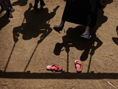 Anak-anak pengungsi Sudan Selatan bermain ayunan saat istirahat makan siang di halaman sekolah pembibitan Ombechi di Bidi Bidi, Uganda, (5/6). Sekolah ini dukung oleh UNICEF dan Save the Children yang memiliki lebih dari 500 murid. (AP Photo/Ben Curtis)