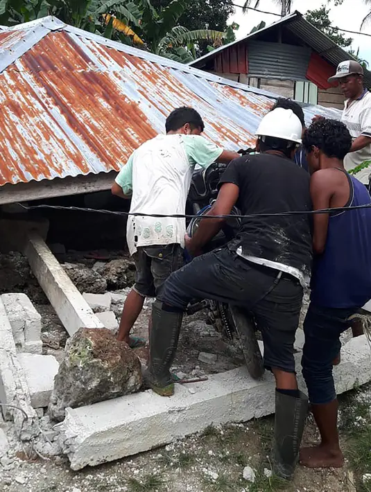 Sejumlah orang mengeluarkan motor dari rumah yang rusak akibat gempa di Ambon, Maluku, Jumat (27/9/2019). Badan Nasional Penanggulangan Bencana (BNPB) mengatakan 171 rumah rusak akibat gempa Magnitudo 6,5 yang mengguncang Maluku pada 26 September 2019. (HO/BADAN NASIONAL PENANGGULANGAN BENCANA/AFP)