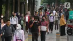 Sejumlah pekerja mengenakan masker melintas saat jam pulang kerja di kawasan Sudirman, Jakarta, Rabu (16/8/2023). (Liputan6.com/Angga Yuniar)