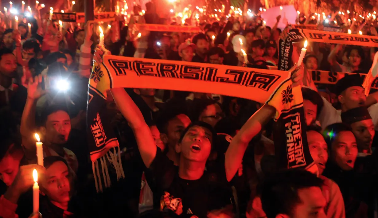 Suporter Persija membentangkan syal dan menyalakan lilin saat aksi di kawasan Stadion GBK Jakarta, Senin (16/5/2016). Aksi ini untuk mengenang wafatnya Fahreza saat akan menyaksikan laga Persija melawan Persela, (13/5). (Liputan6.com/Helmi Fithriansyah)