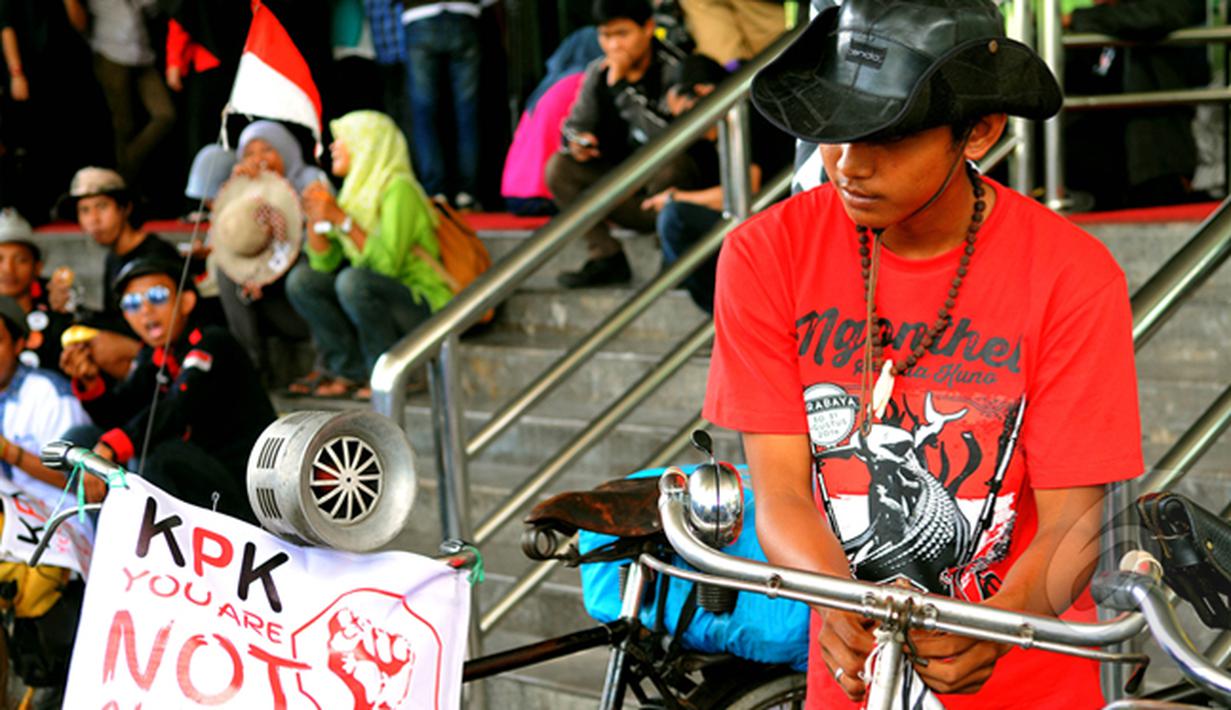 Seorang laki-laki saat mengelar aksi di depan Gedung Komisi Pemberantasan Korupsi (KPK), Jakarta, Senin (16/02/15).  Para pelajar mengayuh sepeda ontel selama 13 hari dari  Jember menuju Jakarta untuk mendukung KPK. (Liputan6.com/Faisal R Syam)