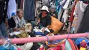 Calon pembeli melihat barang dagangan di depan gedung Pasar Senen, Jakarta, Minggu (22/1). Pasca kebakaran tidak membuat para pedangang putus asa, sebagian dari mereka tetap berjualan meskipun harus di bahu jalan. (Liputan6.com/Helmi Affandi)