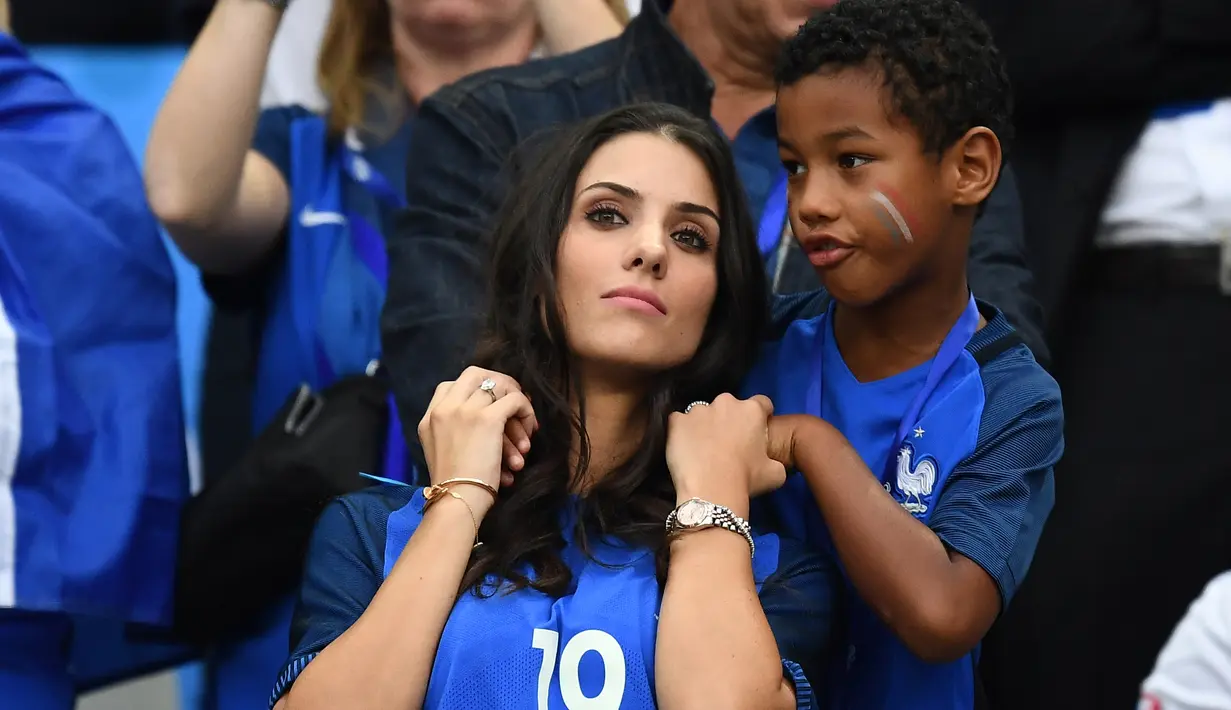 Istri bek Prancis Bacary Sagna, Ludivine Sagan datang bersama buah hatinya menyaksikan sang suami berjuang bersama timnas Prancis melawan Rumania di Stade de France, Saint-Denis, Paris, (10/6). (AFP PHOTO/FRANCK FIFE)