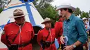 Perdana Menteri Kanada Justin Trudeau berbincang dengan Royal Canadian Mounted Police dalam acara Calgary Stampede di Calgary, Alberta, Kanada (15/7). (Jeff McIntosh / The Canadian Press via AP)